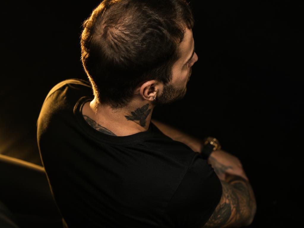Man with thinning crown in gold light